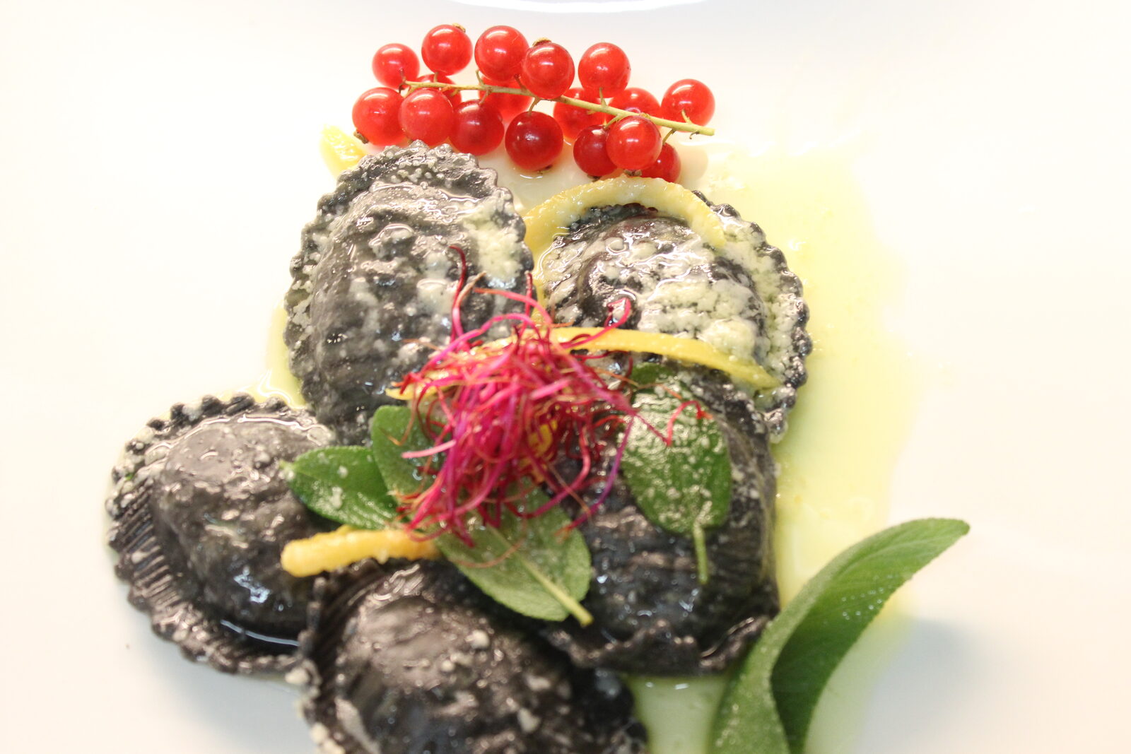Ravioli al nero di seppia con ripieno di Branzino con salsa agli agrumi